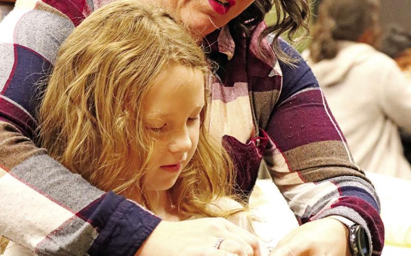 Wallace teacher, Samantha Blanton, assists Marcelina Ortiz