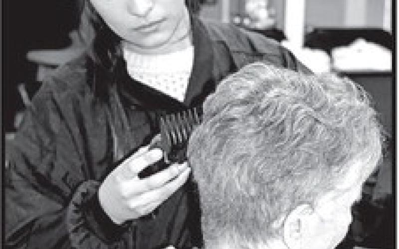JenniferPenaputsfinishingtouchesonacustomer’shaircut