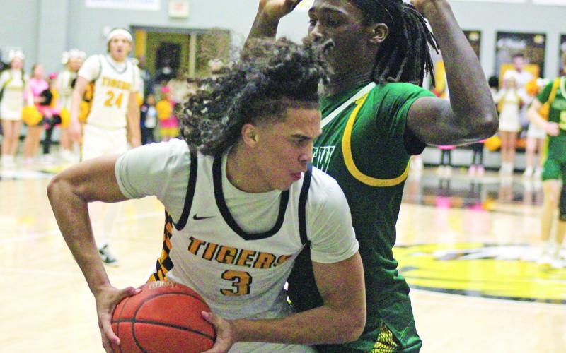 Mount Pleasant’s Kai Price battles with Longview’s Robert Blandburg during Tuesday’s game. The Tigers fell just short against the Lobos, 45-42. Mount Pleasant hosted Marshall Friday and travel to Tyler for their regular season finale Tuesday. TRIBUNE PHOTO / QUINTEN BOYD