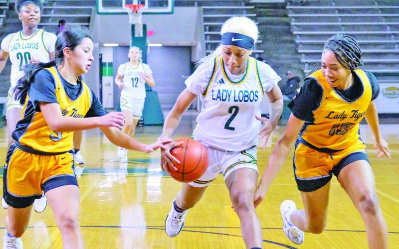 Melany Morales (left) and Shannon Hines (right) defend Longview’s T’Asia McGee during Tuesday’s game. The Lady Tigers fell to the Lady Lobos in the season finale. COURTESY PHOTO / LES HASSELL OF THE LONGVIEW NEWS-JOURNAL