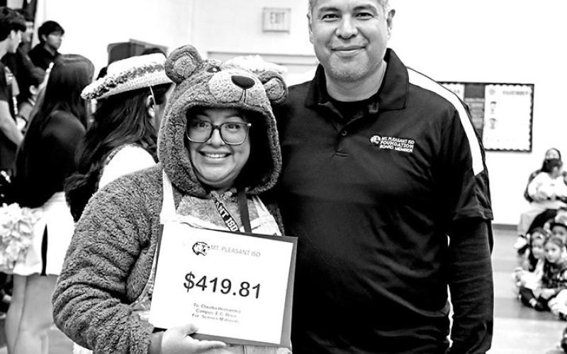 One of the Three Little Bears, a.k.a. Claudia Hernandez, receives a grant from Jose Rodriguez at E.C. Brice Elementary