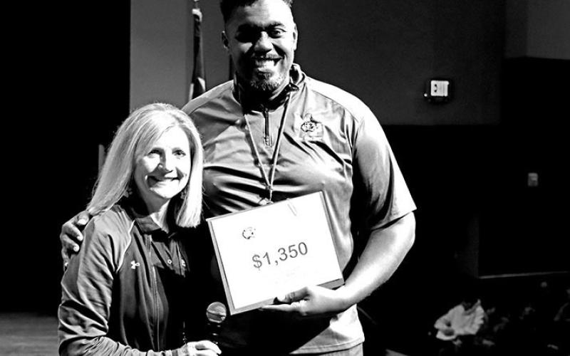 MPISD Fine Arts Director, Theodus Luckett III, accepts a grant for the band program from Deb Malone