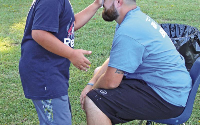 5th grader Josiah Segovia puts a pie in the face of Coach Jared Elliott after making a basket COURTESY PHOTO