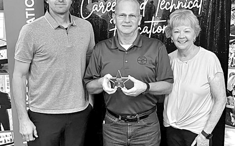 Tim Davis (center) receives his award at a Regional meeting for Regions 7 and 8 in Kilgore with Career and Technology Director, Jay Silman (left) and his wife, Donna Davis, who teaches business classes at Mount Pleasant High School COURTESY PHOTO