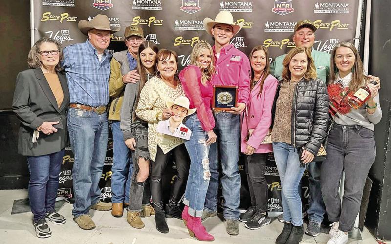 Kincade Henry, center, is surrounded by family and friends in Las Vegas as he holds one of the two gold buckles that he came home with from the 2022 National Finals Rodeo. COURTESY PHOTO