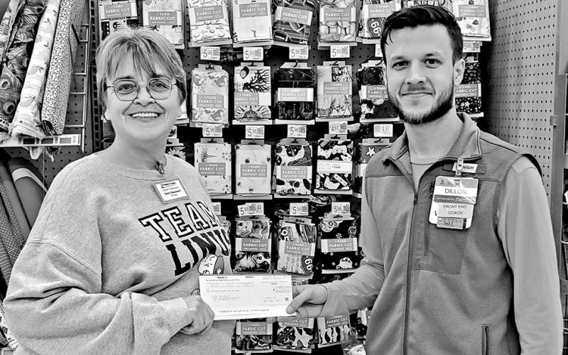 Chapter president Debra Beaumont gratefully accepts a donation from Walmart in Mt. Pleasant for Project Linus. COURTESY PHOTO