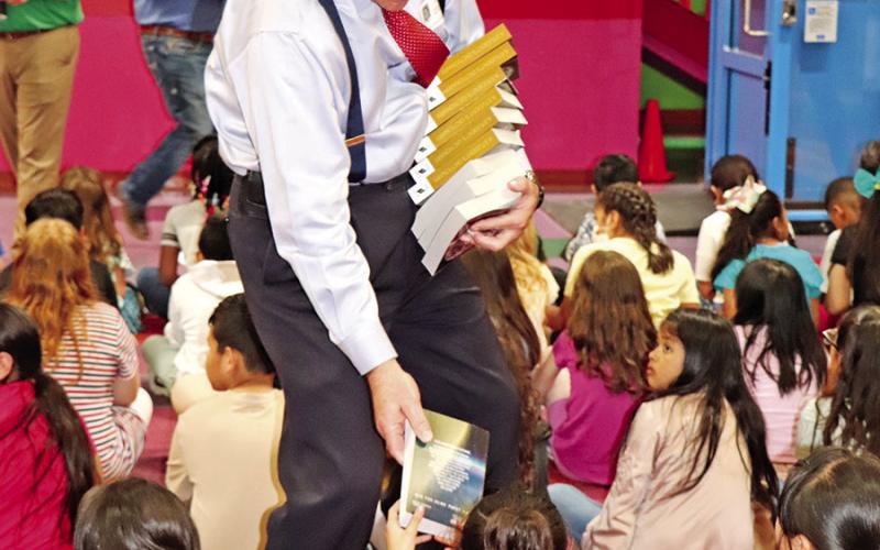 Dr. Clint Davis hands out books at Corprew Elementary