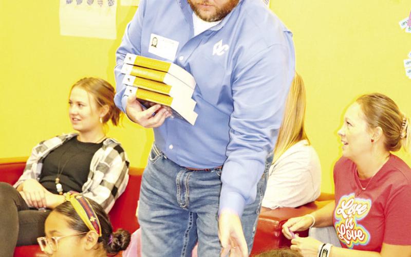 Tyler Verner hands out books at Brice Elementary