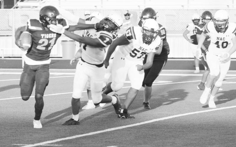 (Above) Mount Pleasant JV quarterback Mason McMinn throws a pass during Thursday’s game against Nacogdoches. McMinn accounted for five touchdowns (two rushing, three passing) in the Tigers’ 55-28 victory. (Below) Isaiah Hunter stiff-arms a Nacogdoches defender during Thursday’s game. The TIger JV remains undefeated on the season after their 55-38 win Thursday night. TRIBUNE PHOTOS / QUINTEN BOYD