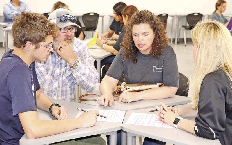 Assistant Principal, Kelli Glenn (right), answers questions from new freshman Conlee Johnson (left) and his parents COURTESY PHOTOS