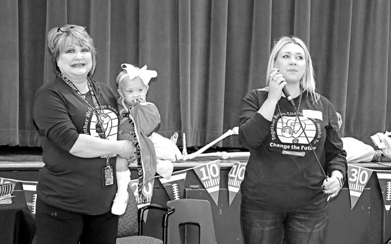 Cari Crooks Onellion (right) speaks to the students at Corprew while Karen Crooks (left) holds granddaughter, Scottie B.