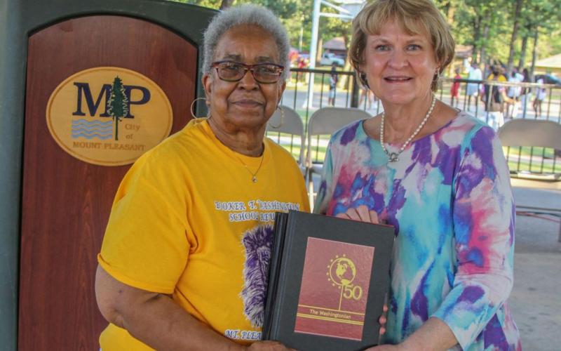 Above from left, Betty Roberson, President of Booker T. Washington High School Alumni Association Council, presented a set of the five recovered and re-published Booker T. Washington High School yearbooks to Helen Thompson, Director of the Mount Pleasant Library. COURTESY PHOTO