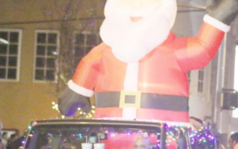 An inflatable Santa sits atop a decorated vehicle at the 2019 Christmas parade. FILE PHOTO