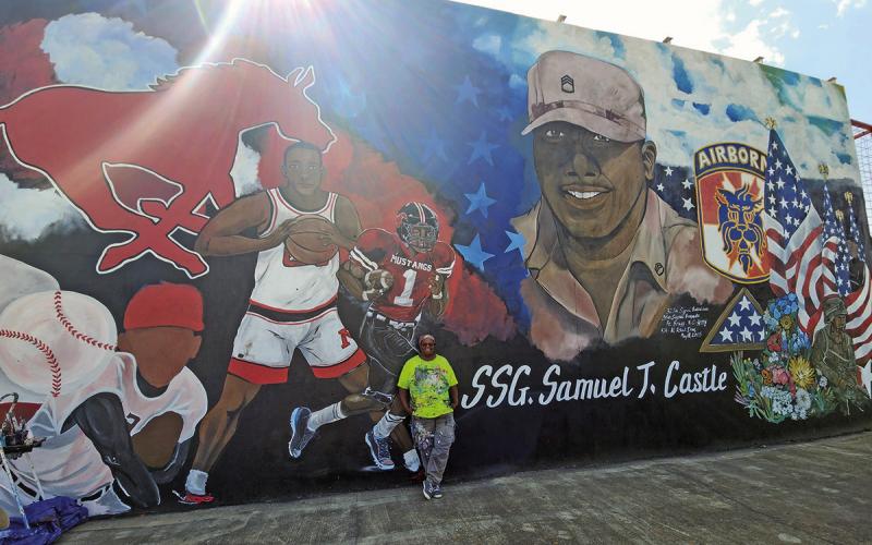 Darlene Taylor posed in front of the mural she worked on, week after week, to honor Sam T. Castle ( Photo by Nicole Kimball)