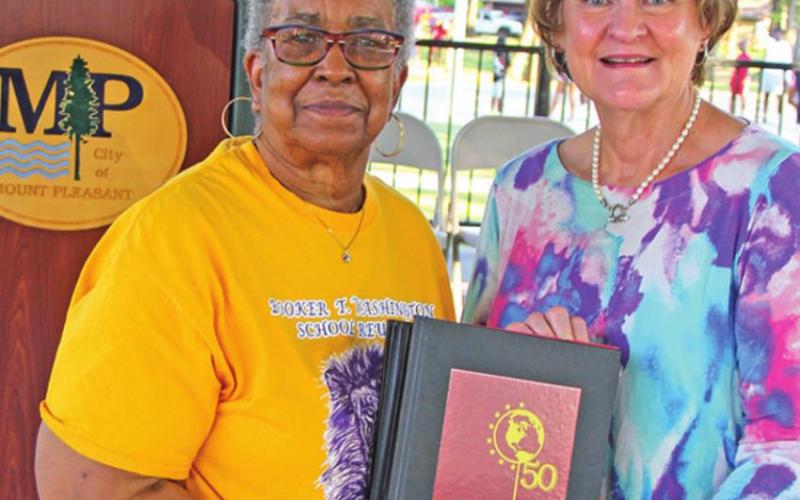From left, Betty Roberson, President of Booker T. Washington High School Alumni Association Council, presented a set of the five recovered and re-published Booker T. Washington High School yearbooks to Helen Thompson, Director of the Mount Pleasant Library.