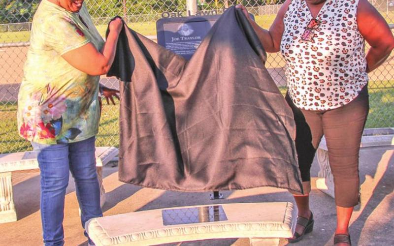 Janice McCoo Royal and Linda Miller Autry unveiled the commemorative bench at the Oaklawn ballfield honoring the Pioneers of Recreation/Oaklawn Community Volunteers and their families.