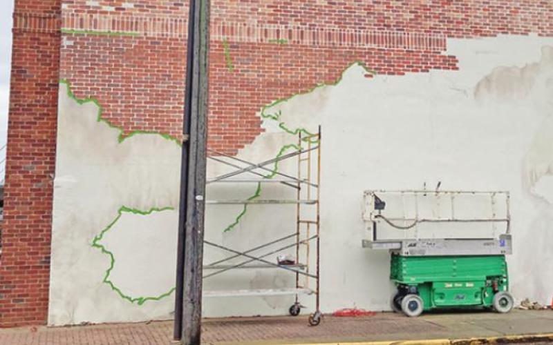Artist David Freeman is currently finishing this patch of bricks and playing with tones to ensure a seamless transition from the front of the building to the side. TRIBUNE PHOTO / DI ANA FITZGERALD