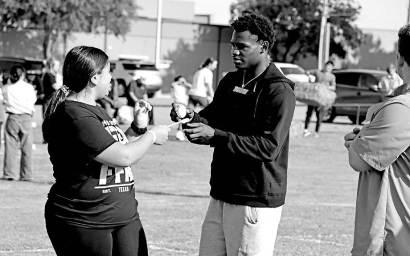 De Corian “Deuce” Thompson helps Abby Torres get ready for her leg of the egg in the spoon race
