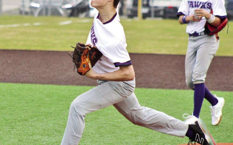 Drew Wigley hurls his final warmup pitch before a game against Dallas HSAA while third baseman Bradon Wafford looks on.