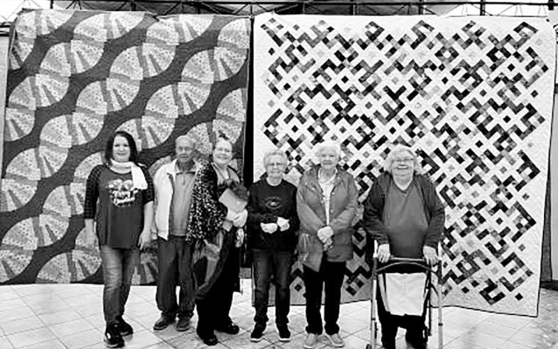 Dr. Karyn Skaar with her daughter, Solveig, in front of the two quilts she displayed in the exhibit. COURTESY PHOTO