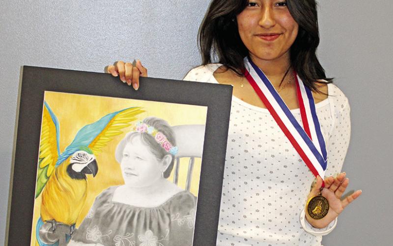 Josue Vega with his state medal piece, “Cowboys” Stephanie Hernandez with her state medal piece, “Eternal Youth”