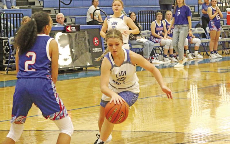 Rivercrest’s Logan Huddleston drives toward the basket as Prairiland’s Randee Maull sets up defensively. The Lady Rebels battled back in Tuesday’s game but fell short, 59-54. TRIBUNE PHOTO / QUINTEN BOYD