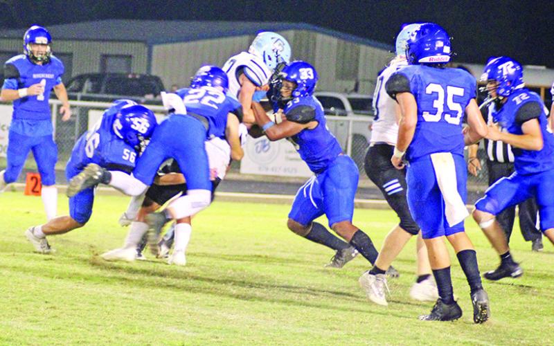 From left, Noah Altal, Dalton Lovett and JaQuan Brown combine to bring down a ball carrier during a recent game. The Rebels will meet Honey Grove Friday at The Swamp. TRIBUNE PHOTO / QUINTEN BOYD