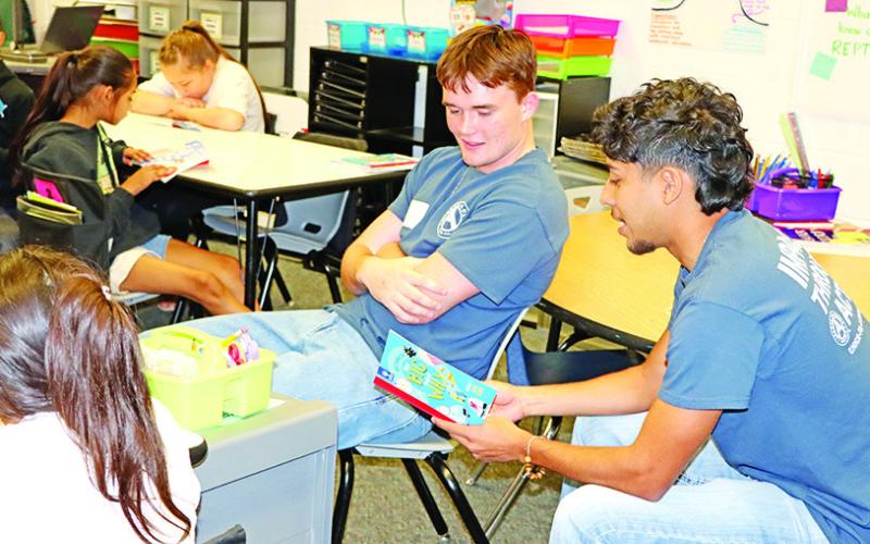 Jesus Moreno (right) and Tanner Marshall read to Aide Perez’s class at Corprew