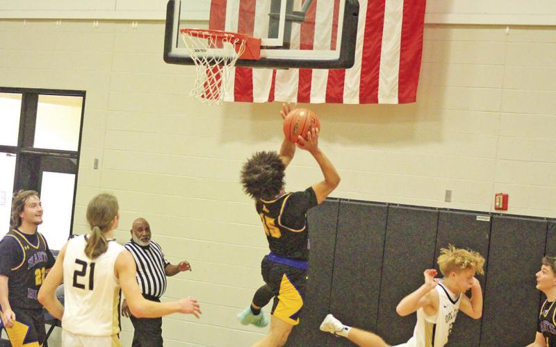 Cayden James drives through the Ore City defense for a layup during their game last week. The Bulldog boys won their last two games of 2023 and opened 2024 Tuesday at home against Winnsboro. TRIBUNE PHOTOS / QUINTEN BOYD