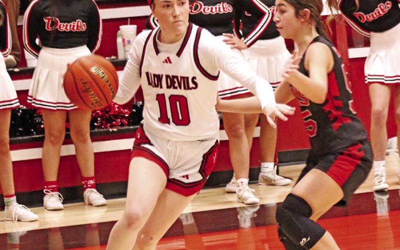 Lady Red Devil senior Keira Hawkins (10) drives around a Paris Home School player during last week’s victory.