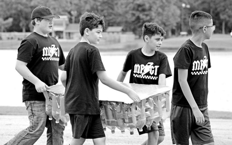 (L to R) Thatcher Drange, Jake Jones, Juan Carrillo, and Joseph Adame carry their creation to the water.