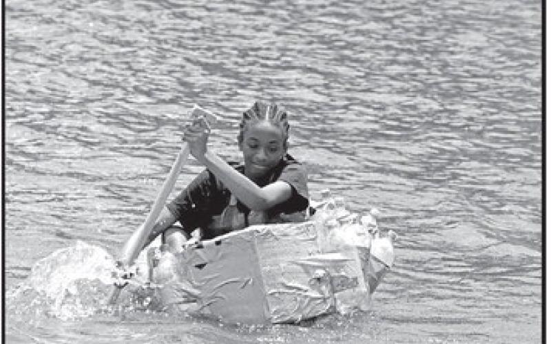 Sixth grader Kezia Williams paddles her winning team’s boat back after tapping the buoy COURTESY PHOTOS