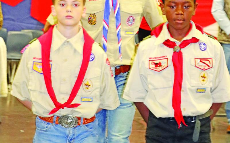 MPHS freshman, Cooper Rider (center), and Wallace sixth graders, Hudson Rider (left) and Robby James (right), of Boy Scout Troop 6101, retrieve the American and Texas flags