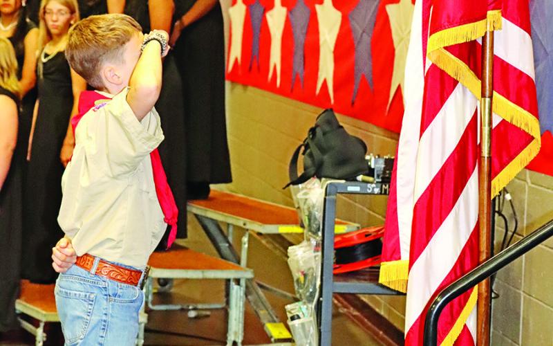 Wallace sixth grader and member of Boy Scout Troop 6101, Hudson Rider, salutes the flag