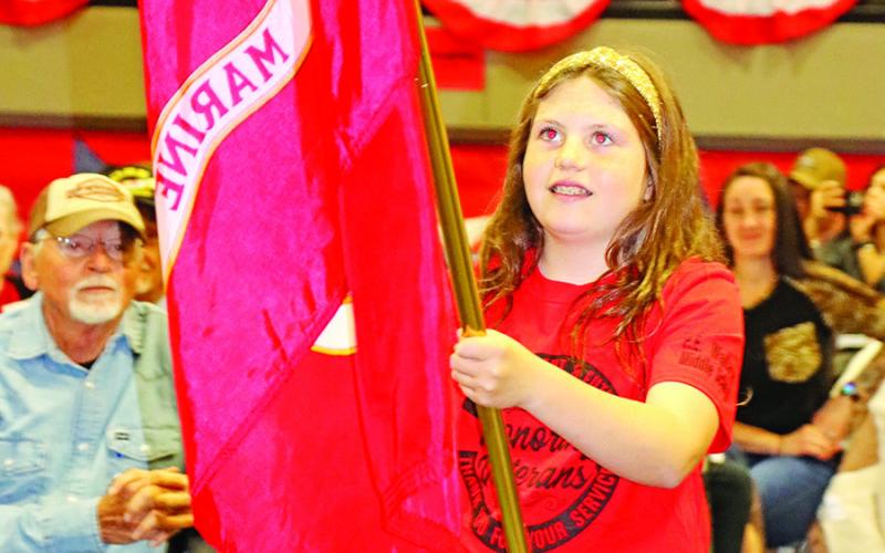 Scottlyn Lee presents the flag of the United States Marines Corp