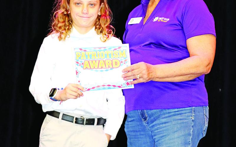 Noah Branton (left) receives his certificate and check from Becky Meriwether for winning the Pilot Club Essay contest