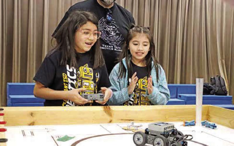 Mallory Mancera (left) and Zuley Banda from the Fowler Brilliant Builders celebrate their robot completing a task.