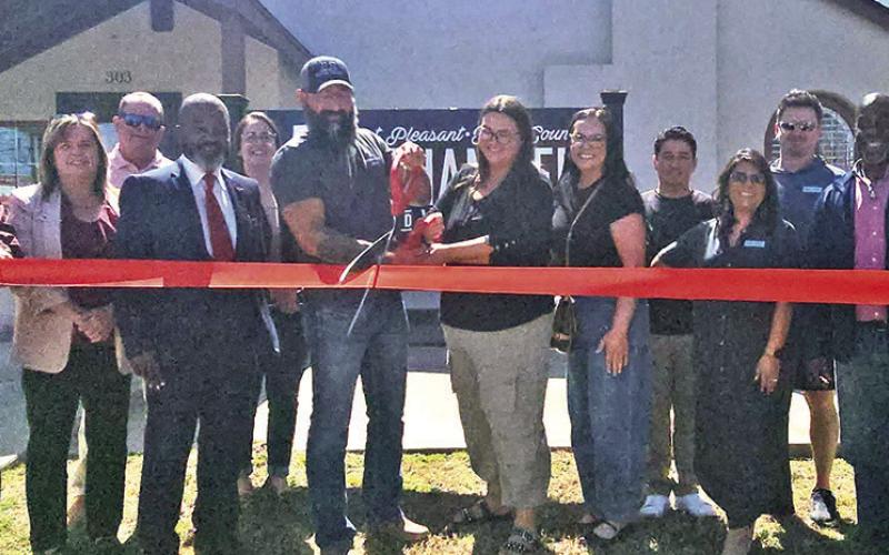 AZ Custom Buildings snip the red ribbon on March 18 COURTESY PHOTO