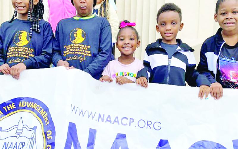 A group of local youth sit on the steps of the Titus County Courthouse at the conclusion of the Martin Luther King. Jr. Day parade on Monday. COURTESY PHOTO