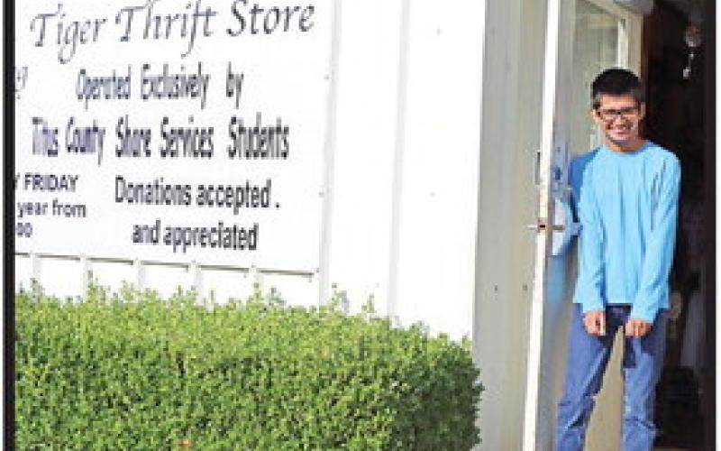 Alex Sandate welcomes customers to the Tiger Thrift Store .