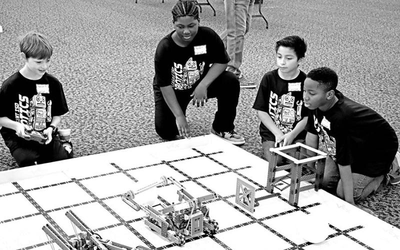 Wallace Team 2 member Samuel Erickstad (left) attempts to capture the ball as (L to R) Karter Fields, Joshuah Antonio, and Kaiden Barber cheer him on