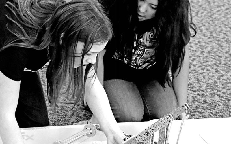 Paisley Hamilton (left) and Allison Castaneda make adjustments to their robot before the matches begin