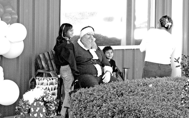 Santa takes photos after asking children what they want for Christmas.