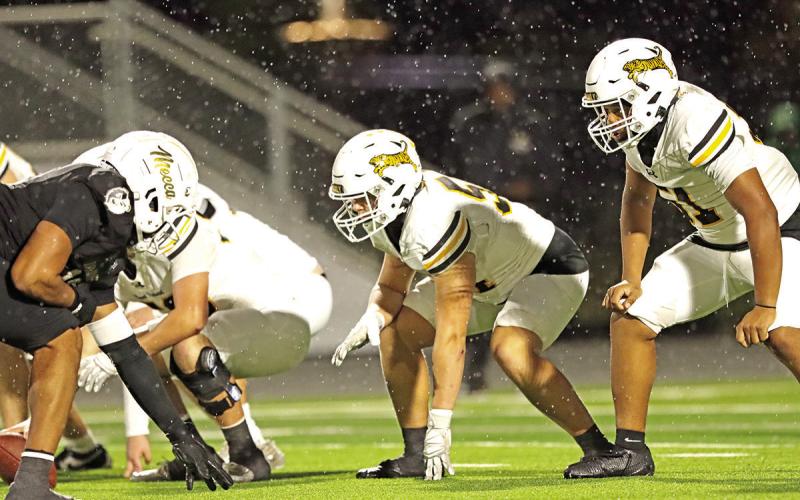 The Tiger Offensive line gets set to battle SOC’s defense as rain pours down during the area playoff game at Better Life Stadium.
