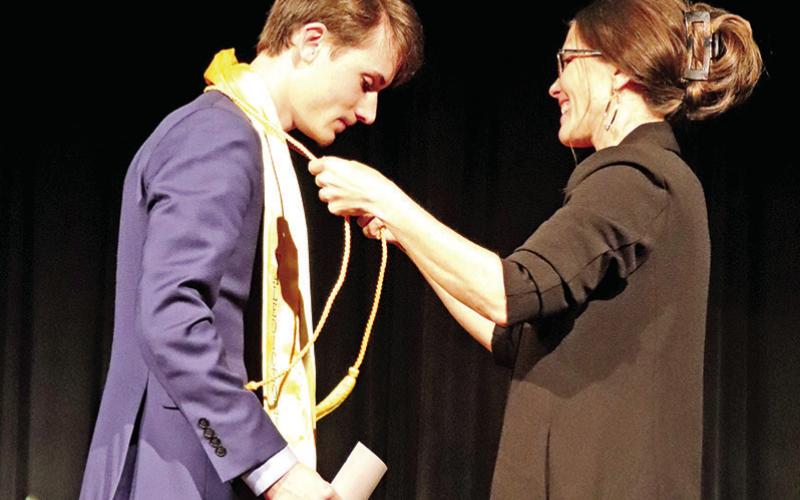 Class of 2023 Valedictorian Ethan Harbour receives his honor graduate cord and valedictorian stole