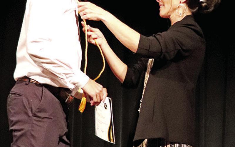 Jones presents Payton Chism his honor graduate cord