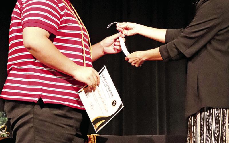 Jones presents Anthony Orellana with his honor graduate tassle