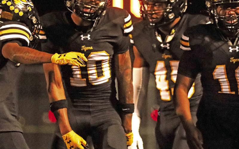 Jeremiah Hurndon celebrates with teammates after returning an interception for a Tiger touchdown.