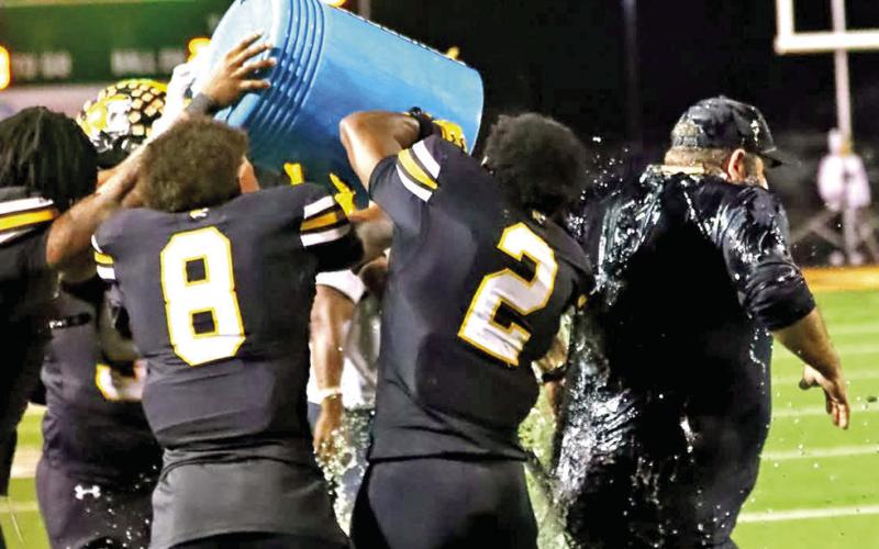 Coach Joey Cluley gets drenched as the Tigers celebrate on Senior Night.