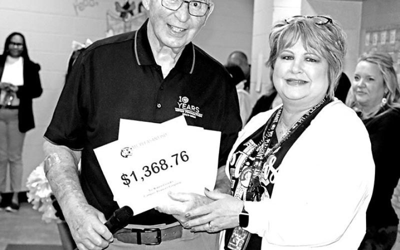 Sam Parker delivers a grant award to Corprew P.E. teacher, Karen Crooks